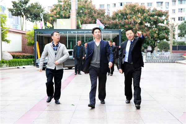 1朱世宏厅长(中)、吴明禹局长(左)、胡东校长(右)走在毓才路上.JPG